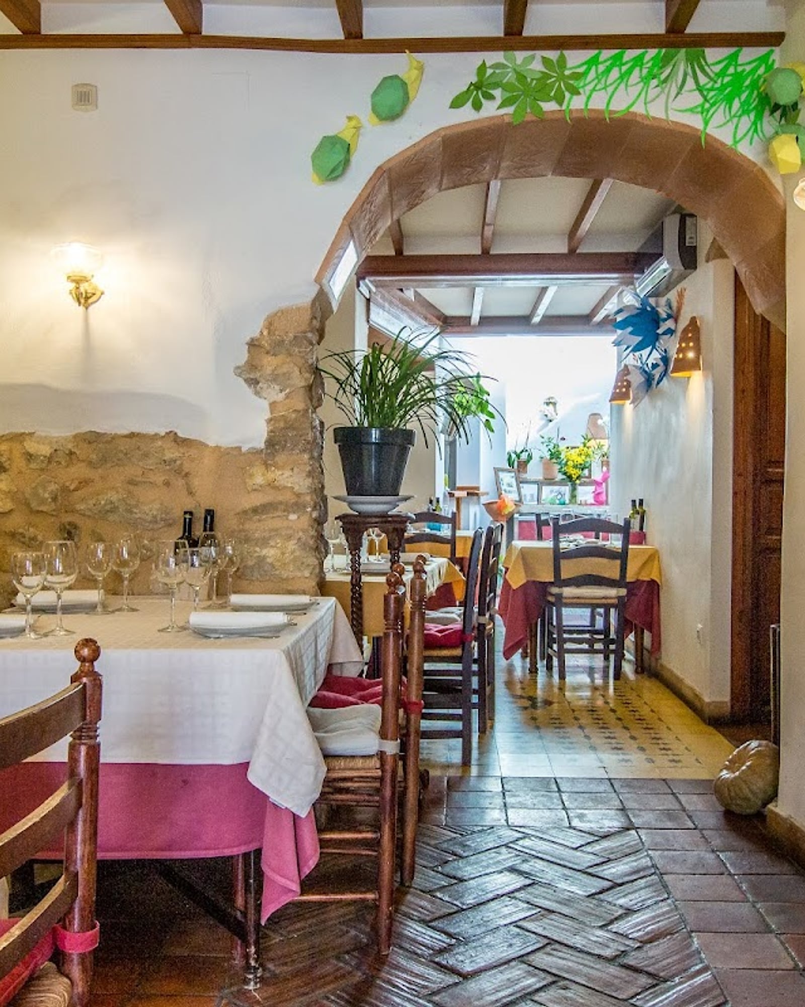 Sala de Cal Morell amb bigues de fusta, arc de pedra i estovalles de tela